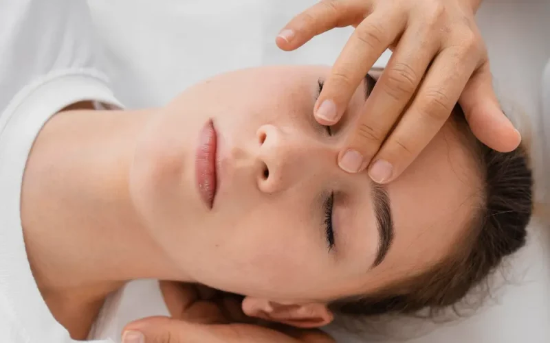 osteopata-leczacy-pacjentke-masujac-jej-twarz